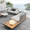Bàn Ghế Sofa Mây Nhựa MN009 với sofa khung gỗ sáng, đệm trắng xám và bàn tròn thấp