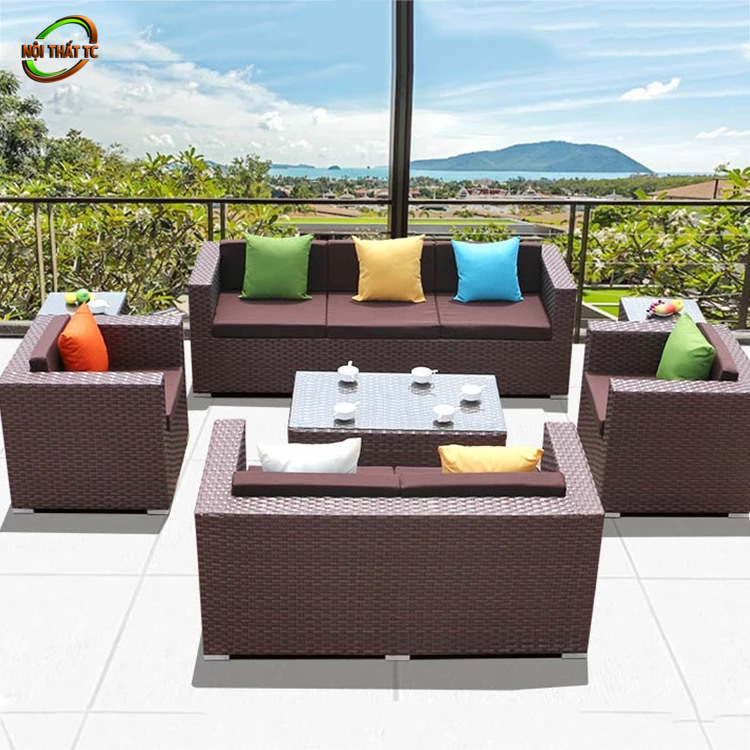 Bàn Ghế Sofa Mây Nhựa MN012 Bàn Ghế Sofa Mây Nhựa MN012 với sofa góc tông nâu đỏ, đệm trắng và bàn trà sáng