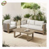 Bàn Ghế Sofa Mây Nhựa MN013 với sofa dài, ghế đơn khung gỗ sáng, đệm kem và bàn trà chữ nhật